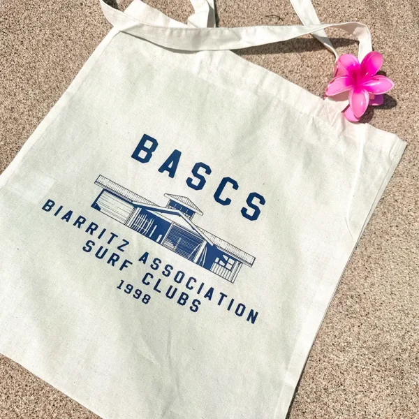 Sac en toile blanc BASCS Biarritz avec pince fleur rose.